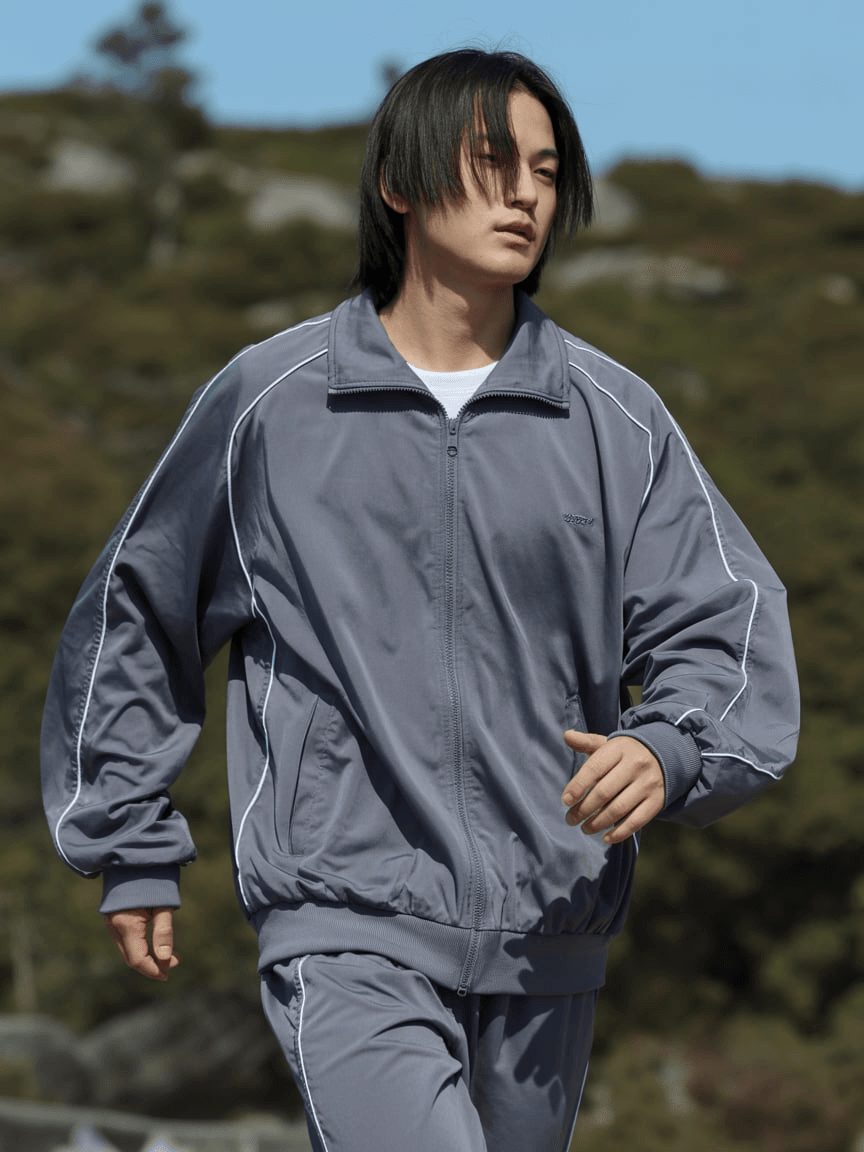 Grey Zip-Up Track Jacket With White Piping Details, Matching Sweatpants, Relaxed Sporty Silhouette In Polyester Fabric.