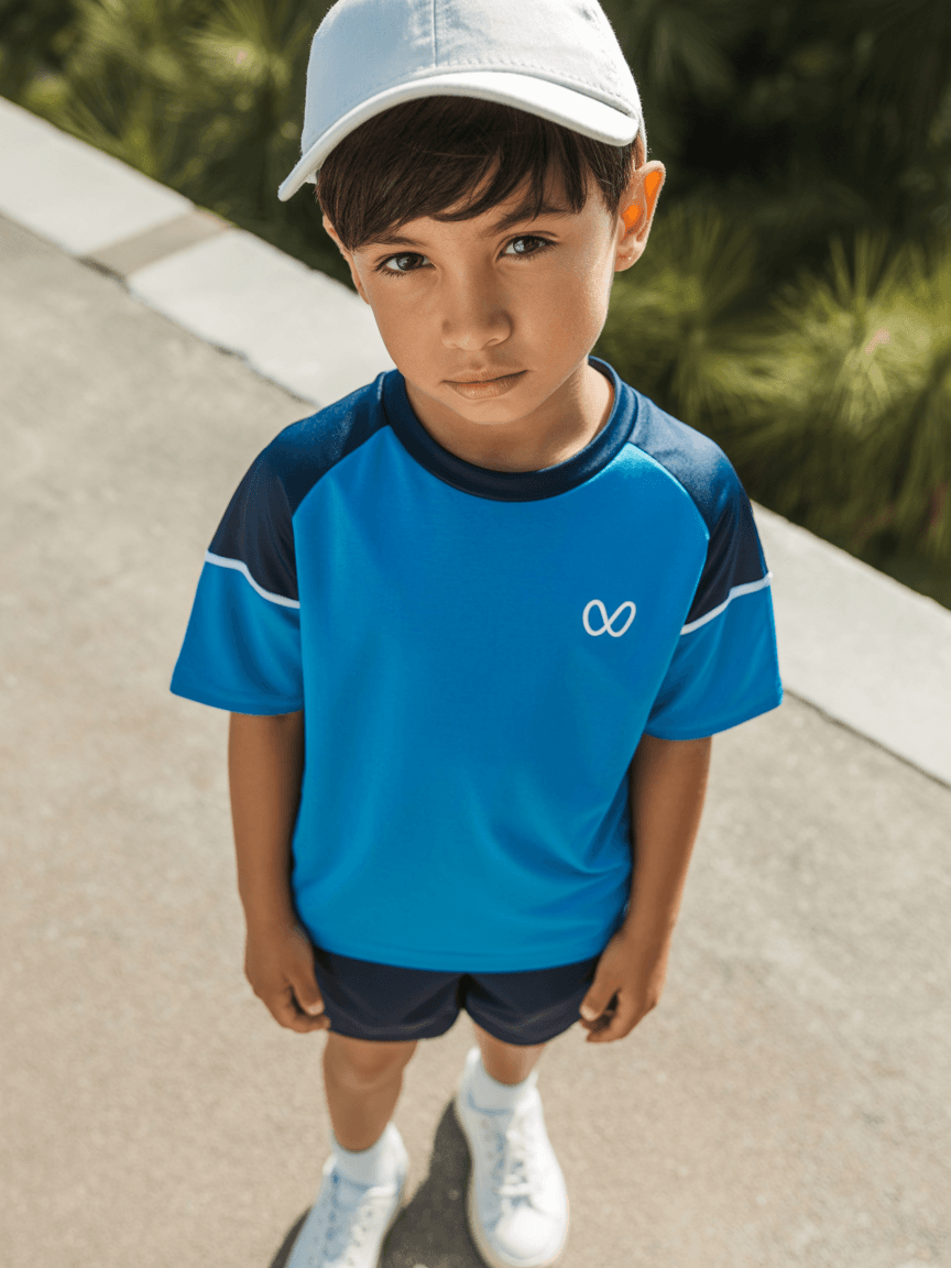 Blue Sports T-Shirt With Contrasting Navy Shorts, Accessorized With A White Cap And White Sneakers