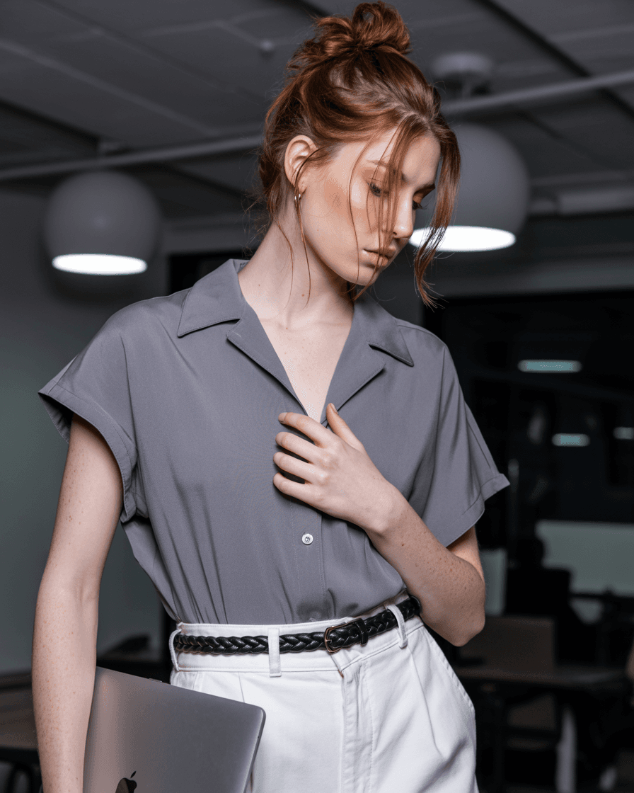 Gray Short-Sleeve Shirt, White Pants, Black Braided Belt, Holding A Laptop.