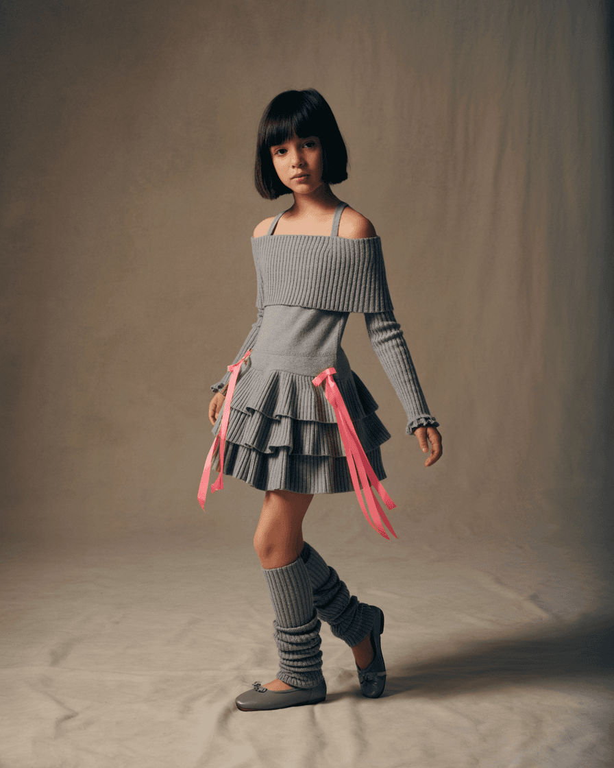 Grey Off-Shoulder Knit Dress With Layered Ruffled Skirt And Pink Ribbon Accents, Paired With Matching Leg Warmers And Grey Ballet Flats